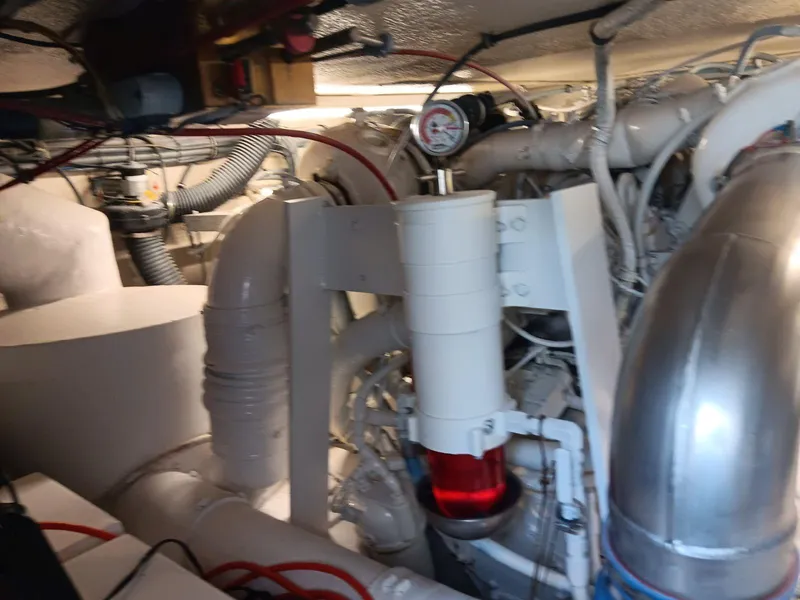 Slide: The Image of Engine room of 1988 Hatteras 48 Convertible yacht, showcasing complex machinery and piping. - 45