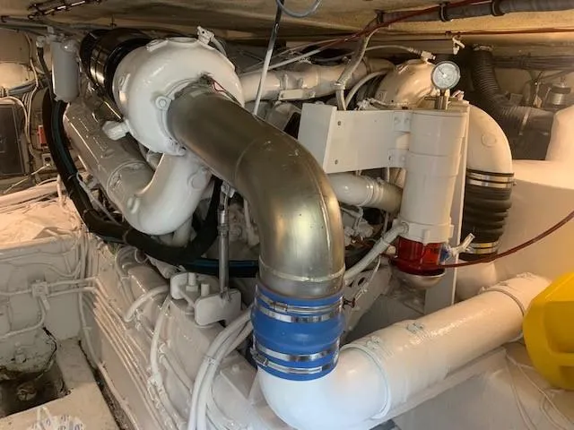 Slide: The Image of Engine room of 1988 Hatteras 48 Convertible yacht, showcasing complex machinery and piping. - 46