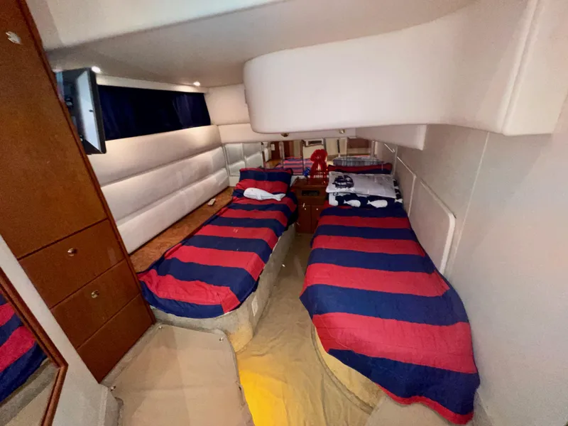 Slide: The Image of Interior of 2006 Silverton 43 Sport Bridge with twin beds and striped bedding. - 26