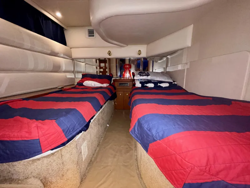 Slide: The Image of Interior cabin of 2006 Silverton 43 Sport Bridge with twin beds and striped bedding. - 27