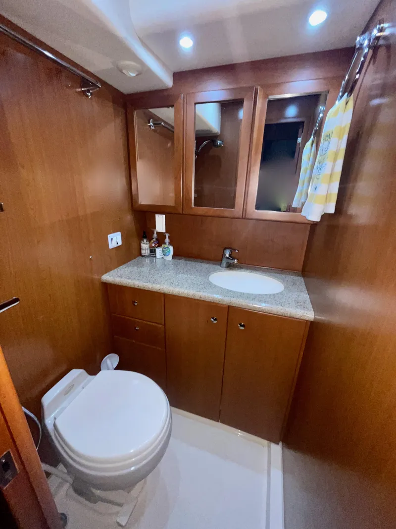Slide: The Image of 2006 Silverton 43 Sport Bridge bathroom with wood cabinetry and modern fixtures. - 28