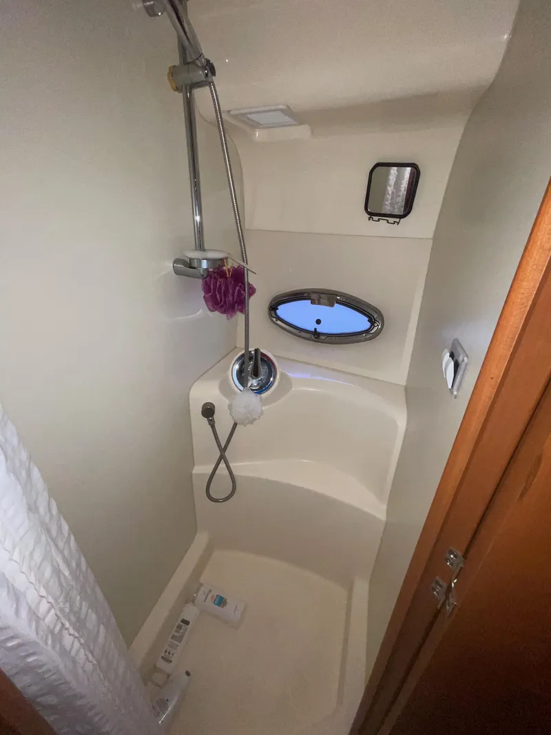 Slide: The Image of 2006 Silverton 43 Sport Bridge shower with porthole and modern fixtures. - 29
