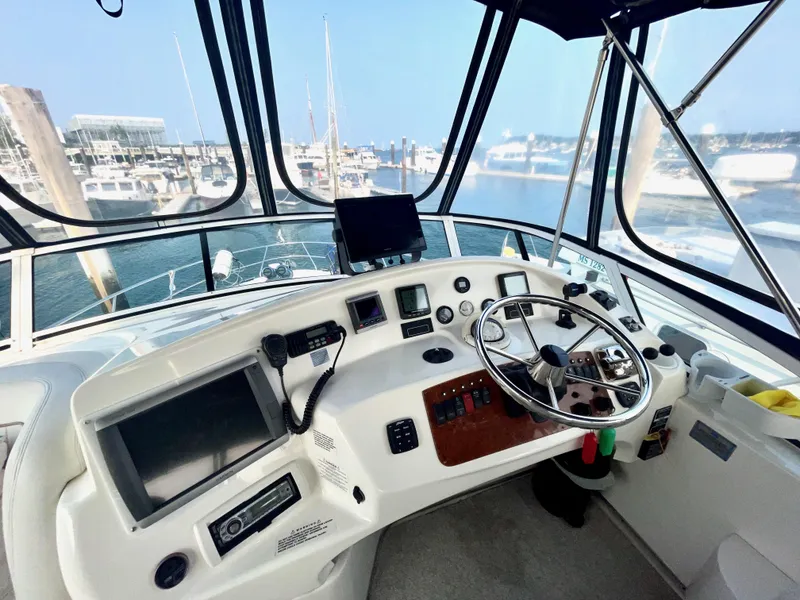 Slide: The Image of 2006 Silverton 43 Sport Bridge helm with navigation equipment and marina view. - 32