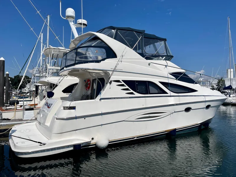 Slide: The Image of 2006 Silverton 43 Sport Bridge yacht docked in marina, clear blue sky. - 47