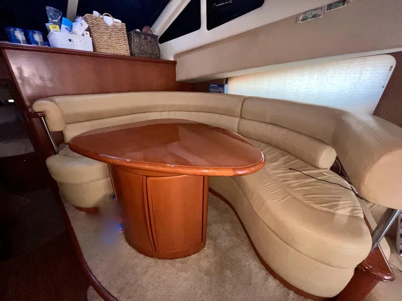 Slide: The Image of Luxurious interior of 2006 Silverton 43 Sport Bridge yacht with curved seating and wooden table. - 7
