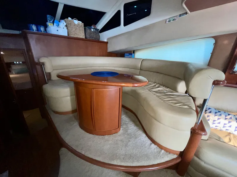 Slide: The Image of Luxurious interior of 2006 Silverton 43 Sport Bridge yacht with curved seating and wooden table. - 8
