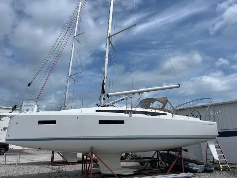 The Image of 2025 Jeanneau Sun Odyssey 380 sailboat on stands, under a cloudy sky. - 0