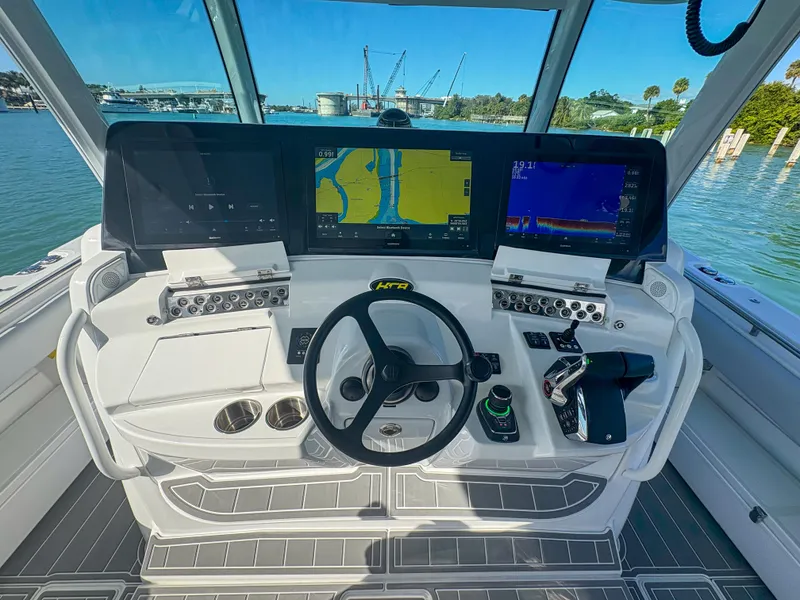 Slide: The Image of 2024 HCB 53' Suenos helm with advanced navigation displays and controls, overlooking a scenic waterfront. - 25