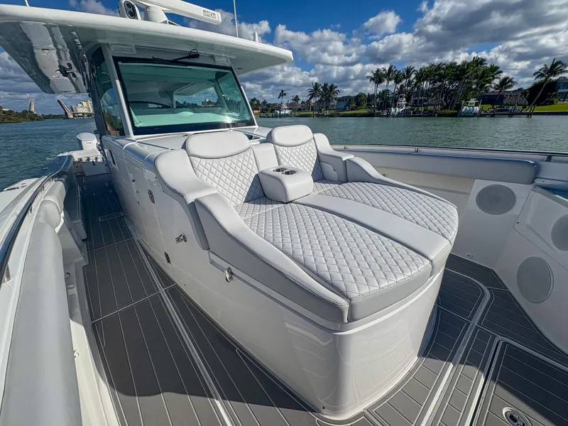 Slide: The Image of 2024 HCB 53' Suenos luxury boat with plush seating, cruising on a sunny day. - 33