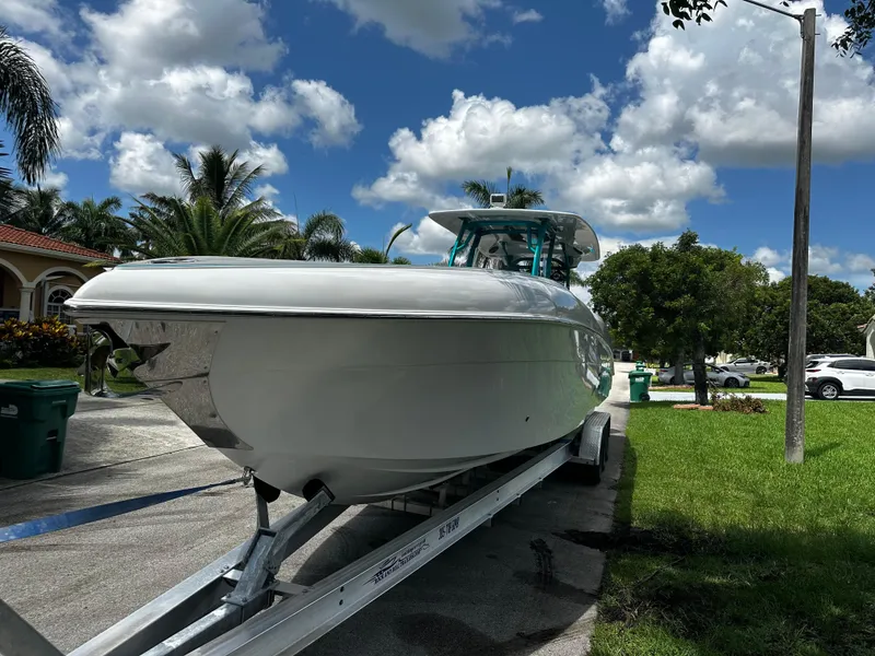 Slide: The Image of 2021 Renegade 38 Open boat on trailer under a sunny sky. - 2
