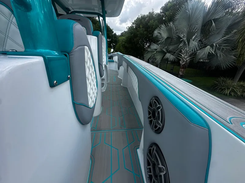 Slide: The Image of 2021 Renegade 38 Open boat interior with teal and gray accents, featuring speakers and seating. - 29