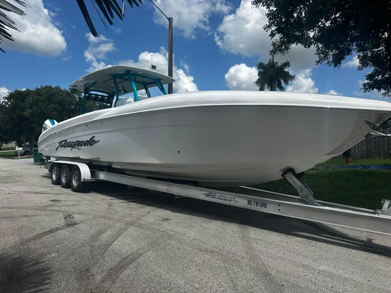 Slide: The Image of 2021 Renegade 38 Open boat on trailer, parked outdoors under a blue sky. - 3