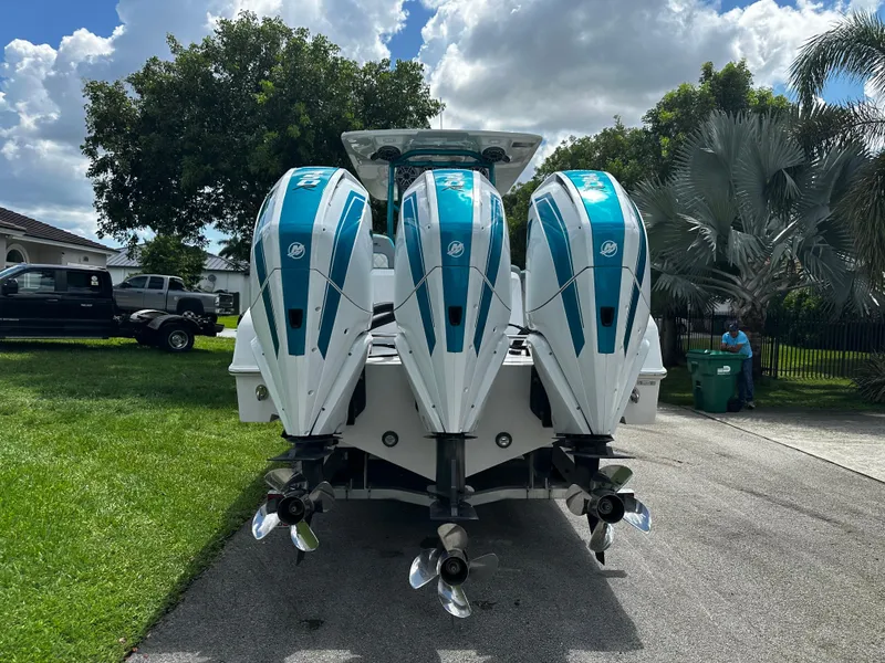 Slide: The Image of 2021 Renegade 38 Open boat with triple outboard engines, parked on a driveway. - 36