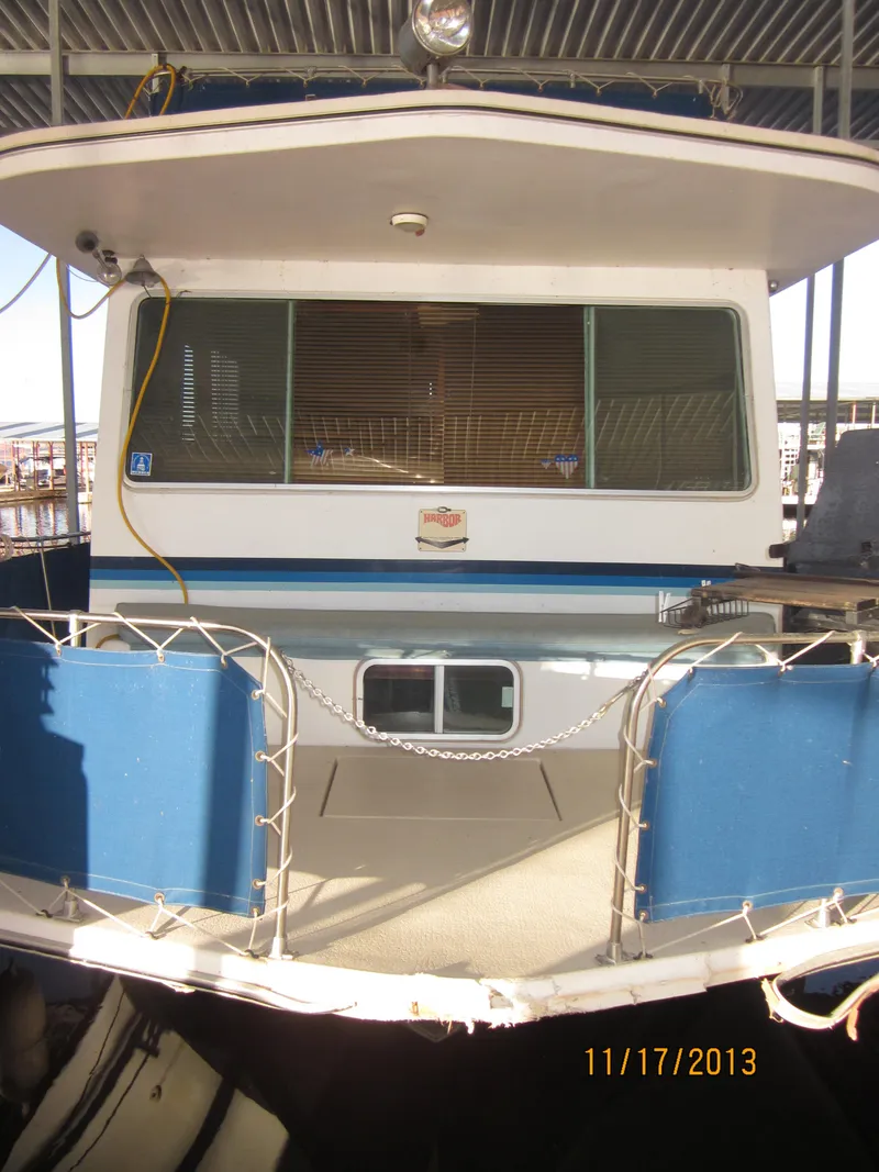 Slide: The Image of 1976 Harbor Master houseboat with blue accents, docked under a covered marina. - 10
