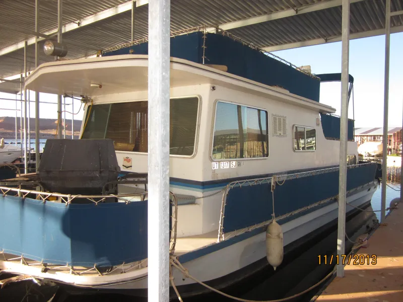 Slide: The Image of 1976 Harbor Master houseboat docked under a covered marina. - 12