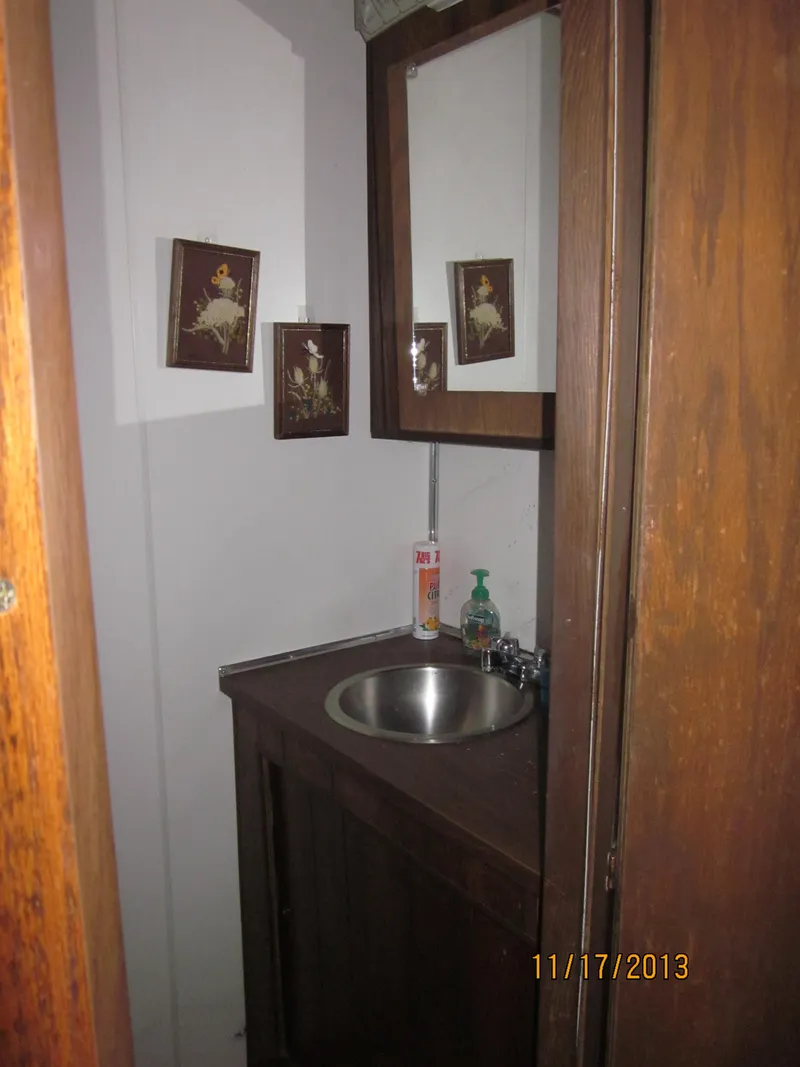 Slide: The Image of 1976 Harbor Master houseboat bathroom with sink, mirror, and decorative wall art. - 14