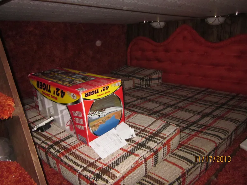 Slide: The Image of 1976 Harbor Master houseboat interior with plaid bedding and a model boat box. - 4