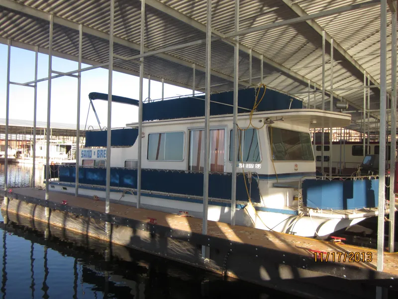 Slide: The Image of 1976 Harbor Master houseboat docked under a covered marina. - 9