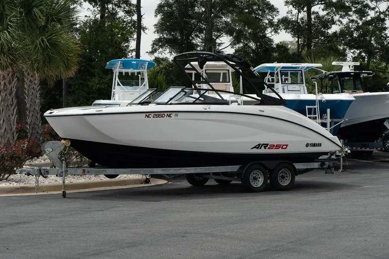 The Image of 2024 Yamaha AR250 boat on trailer, parked outdoors. - 1