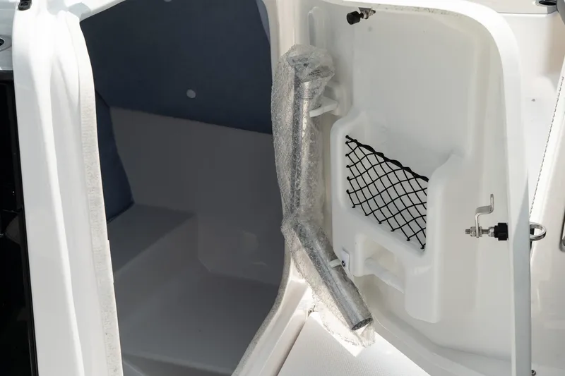 Slide: The Image of 2024 Yamaha AR250 boat storage compartment with netting and wrapped accessory. - 27