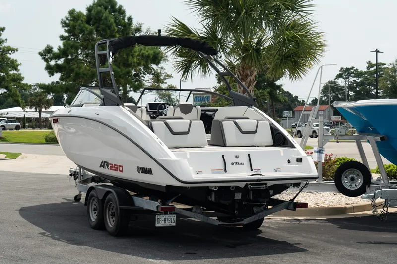 Slide: The Image of 2024 Yamaha AR250 boat on trailer, parked outdoors near palm trees. - 4