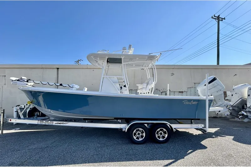 The Image of 2025 Pair Customs 24 Center Console MV boat on trailer, blue hull, dual engines. - 0