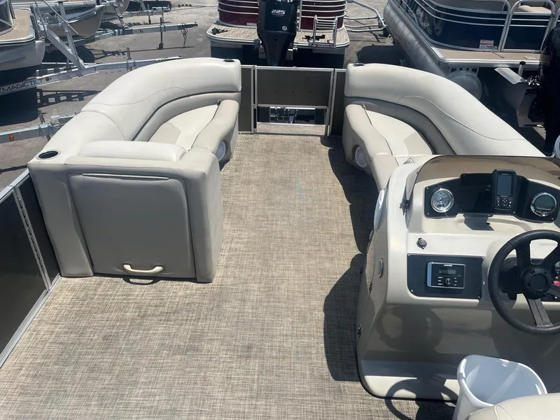Slide: The Image of 2022 Cypress Cay Seabreeze 232 pontoon boat interior with beige seating and helm. - 2