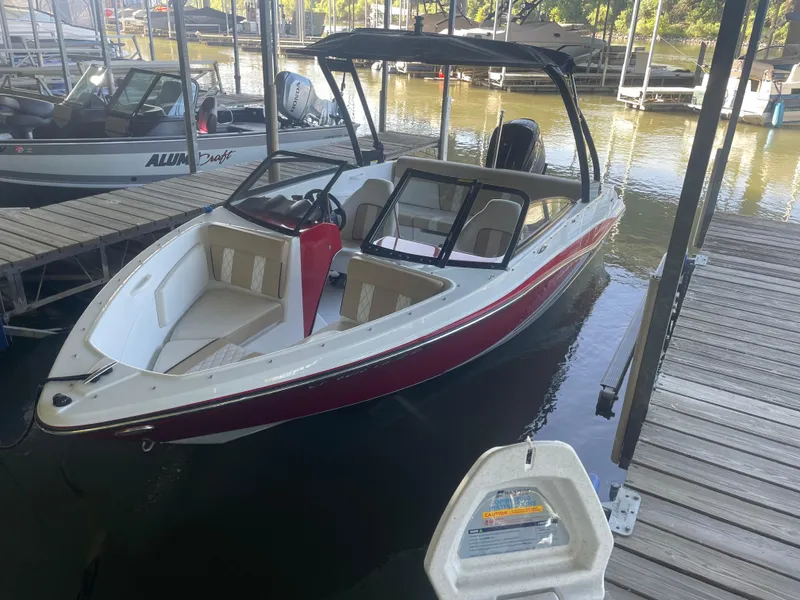 Slide: The Image of 2020 Glastron GT 180 boat docked at marina, red and white exterior. - 0