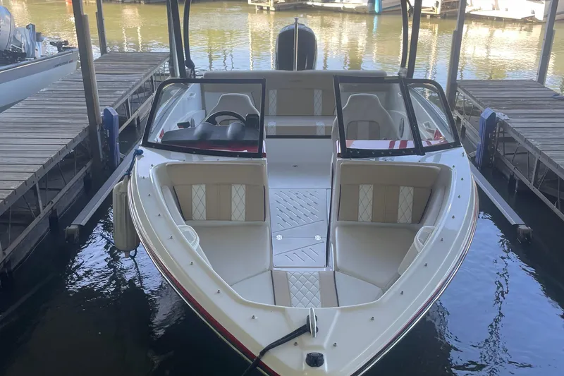 Slide: The Image of 2020 Glastron GT 180 boat docked, featuring sleek design and spacious seating. - 7