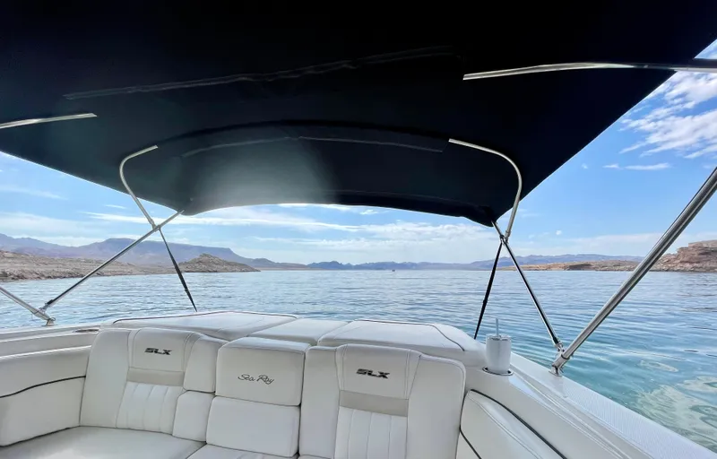 Slide: The Image of 2008 Sea Ray 270 SLX boat interior with canopy on a serene lake. - 12