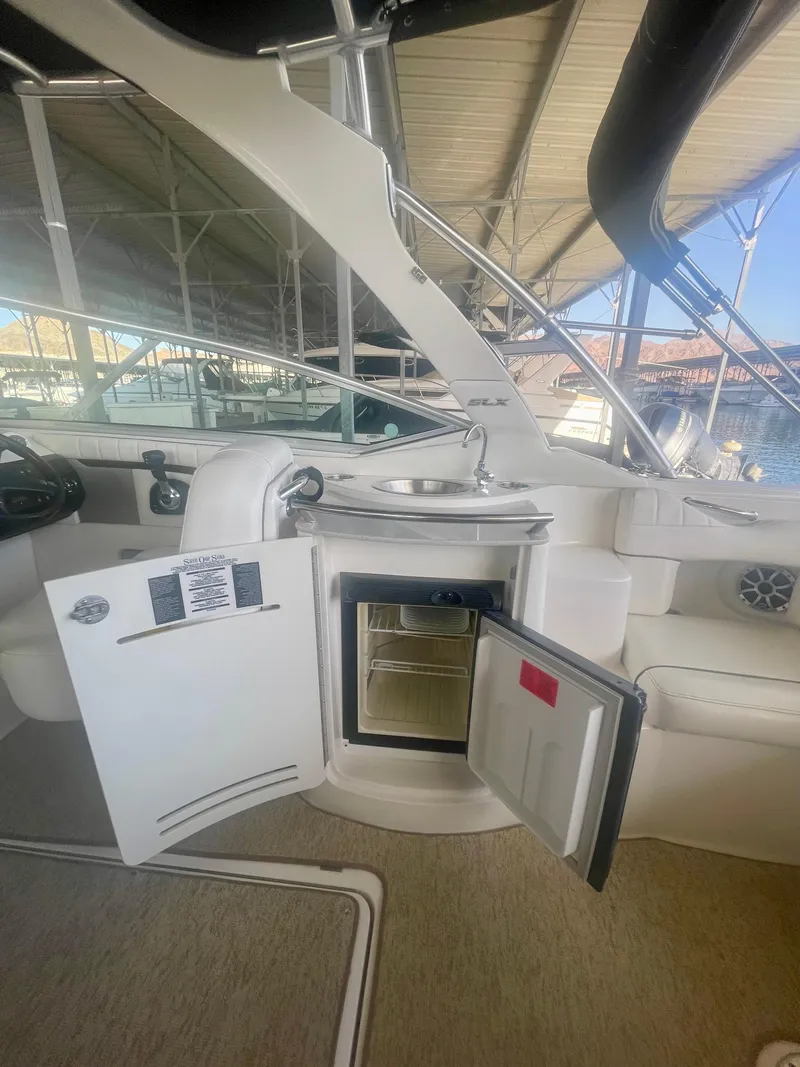Slide: The Image of 2008 Sea Ray 270 SLX interior with open mini fridge and sink. - 26