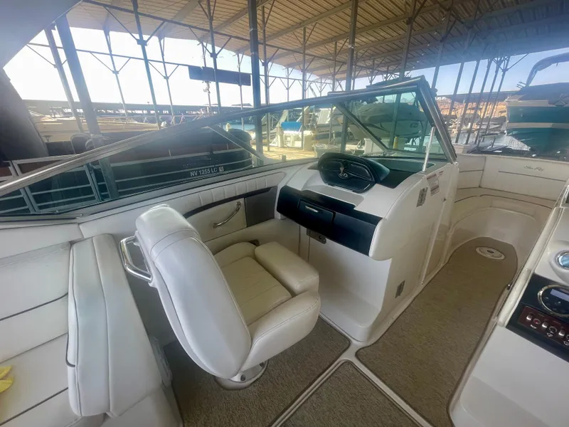 Slide: The Image of 2008 Sea Ray 270 SLX boat interior with helm and seating under a covered dock. - 28