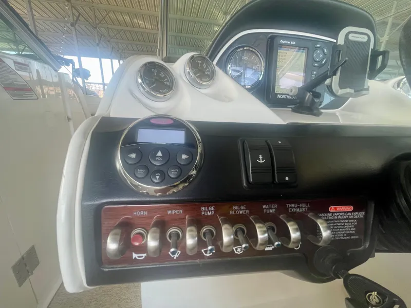 Slide: The Image of 2008 Sea Ray 270 SLX dashboard with controls and gauges in a covered area. - 32