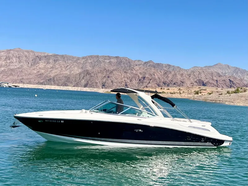 Slide: The Image of 2008 Sea Ray 270 SLX boat cruising on a clear blue lake with mountain backdrop. - 8