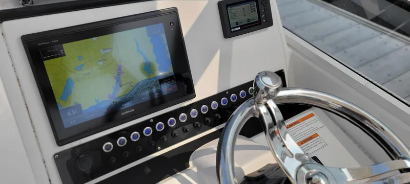 Slide: The Image of Edgewater 230 CX 2019 boat dashboard with navigation screen and steering wheel. - 7
