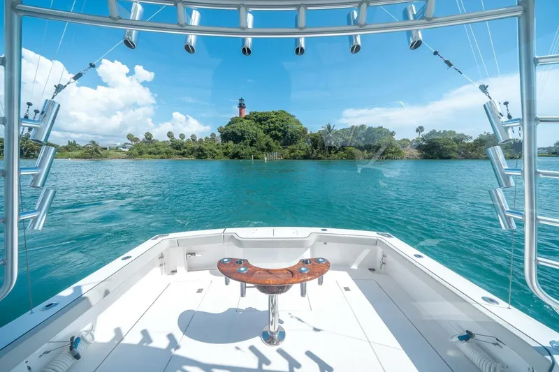 Slide: The Image of Cabo 40 Express 2020 yacht with scenic ocean view and distant lighthouse. - 32