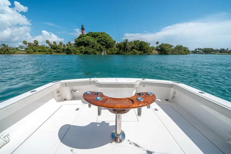 Slide: The Image of 2020 Cabo 40 Express boat with scenic ocean view and distant lighthouse. - 33