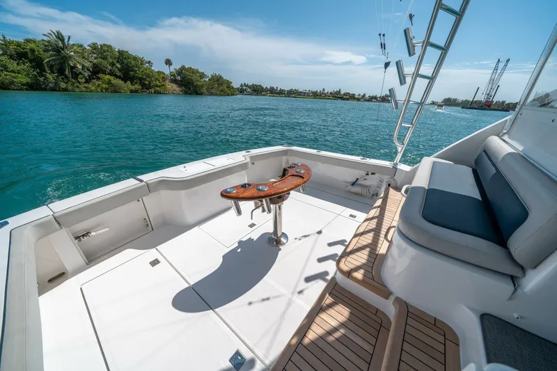 Slide: The Image of 2020 Cabo 40 Express boat deck with seating, fishing rod holders, and scenic water view. - 34