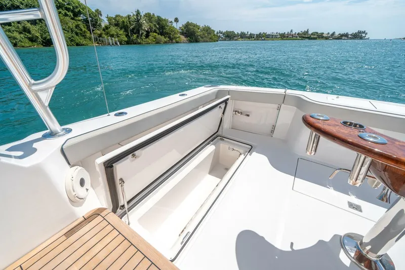 Slide: The Image of 2020 Cabo 40 Express yacht deck with open storage, overlooking serene blue waters. - 38