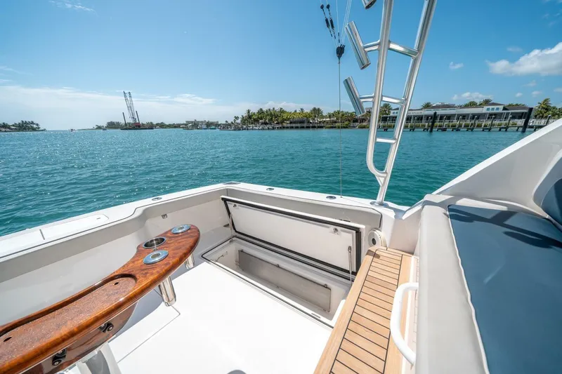 Slide: The Image of 2020 Cabo 40 Express boat deck with fishing rod holders, overlooking serene blue waters. - 41