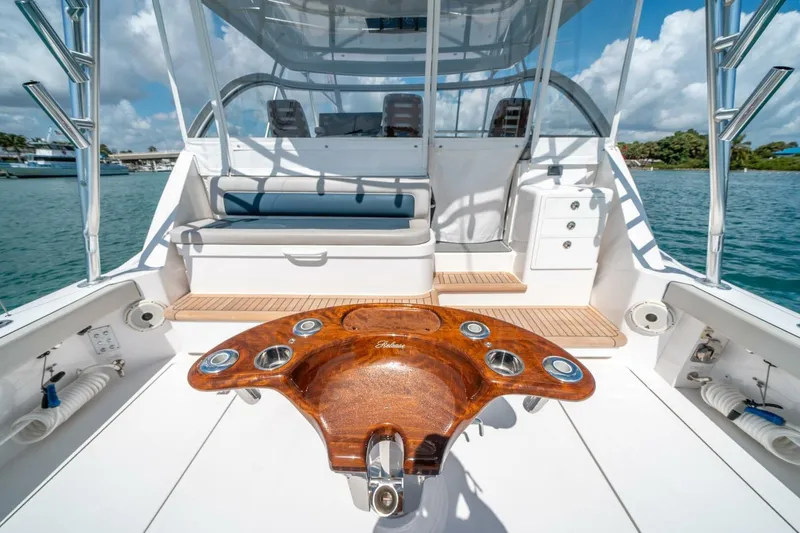 Slide: The Image of 2020 Cabo 40 Express yacht deck with wooden table, ocean view, and seating area. - 43