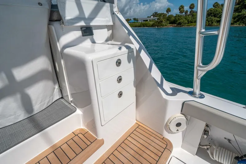 Slide: The Image of 2020 Cabo 40 Express boat interior with storage drawers and teak flooring by the water. - 44