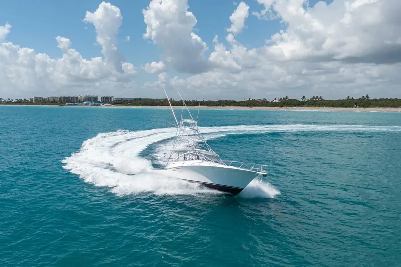 Slide: The Image of 2020 Cabo 40 Express yacht cruising on clear blue ocean under a partly cloudy sky. - 5