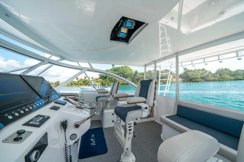 Slide: The Image of 2020 Cabo 40 Express yacht interior with modern helm, seating, and scenic water view. - 51