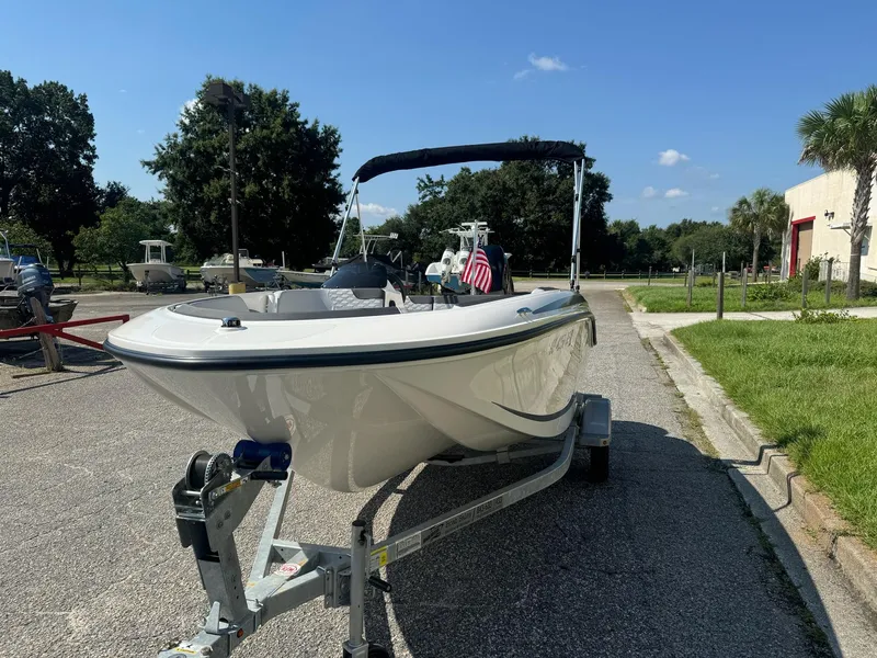 Slide: The Image of 2024 Bayliner Element M15 boat on trailer, parked outdoors under clear blue sky. - 3