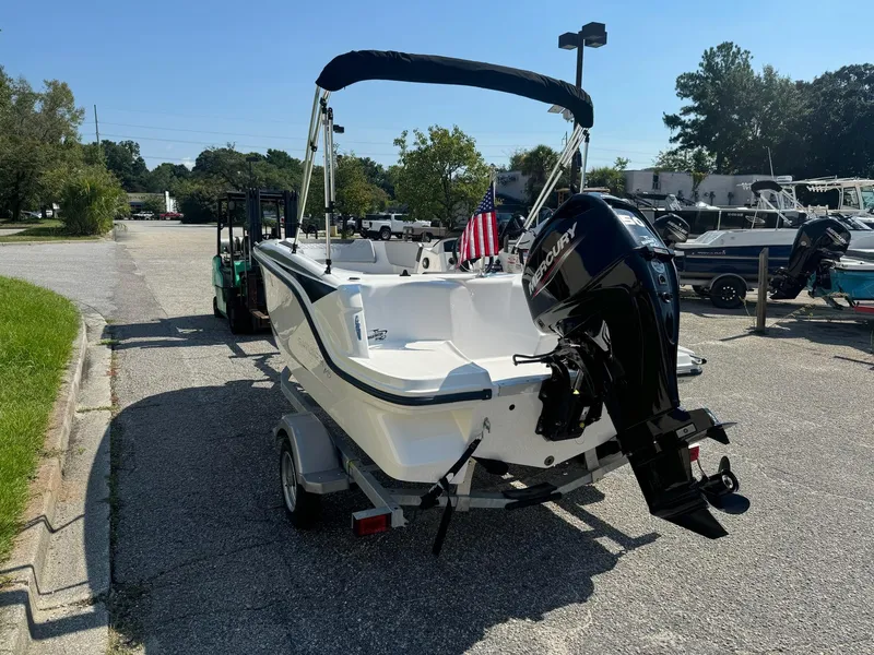 Slide: The Image of 2024 Bayliner Element M15 boat with outboard motor on a trailer, parked outdoors. - 6