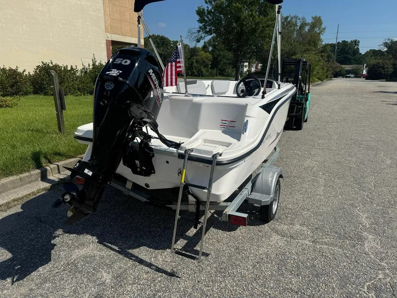 Slide: The Image of 2024 Bayliner Element M15 boat on trailer with outboard motor, parked outdoors. - 9