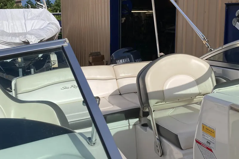 Slide: The Image of 2012 Sea Ray 200 Sundeck boat interior with white seating and Yamaha engine in background. - 12