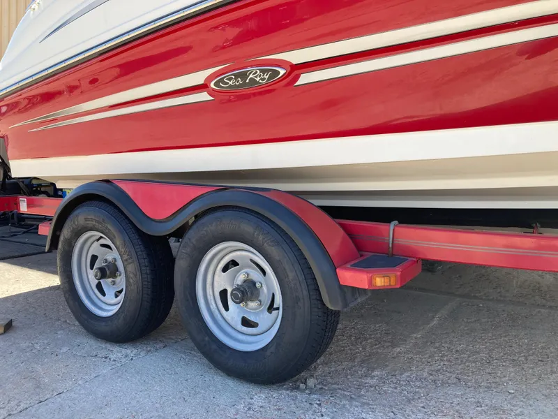 Slide: The Image of 2012 Sea Ray 200 Sundeck boat on a red trailer, side view. - 3
