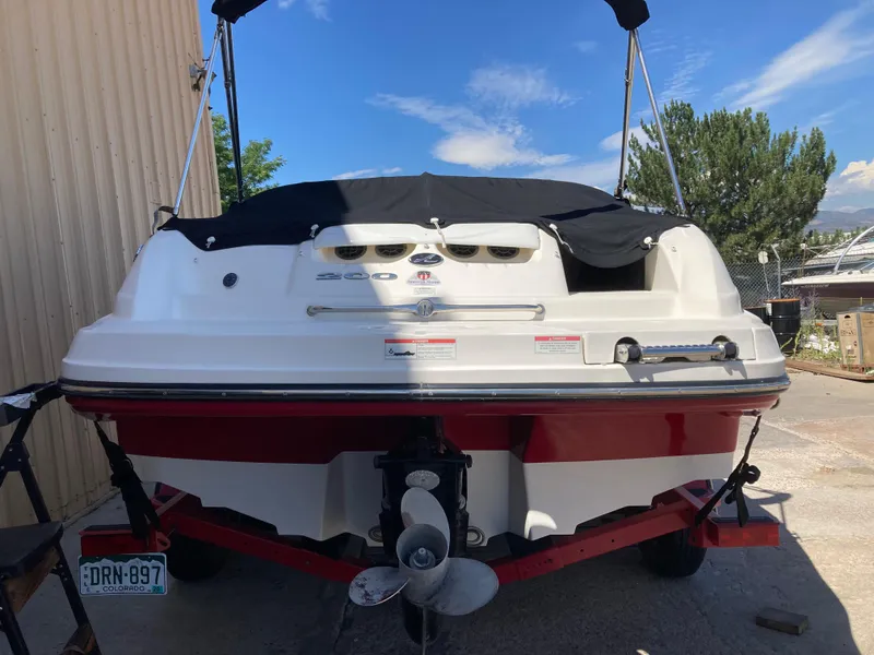 Slide: The Image of 2012 Sea Ray 200 Sundeck boat, rear view, parked outdoors with cover and trailer. - 4